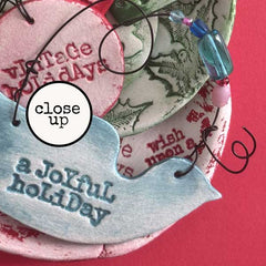 Close-up of decorative holiday ornaments  made with Das Air Dry Clay and Red Lead Rubber Stamps 